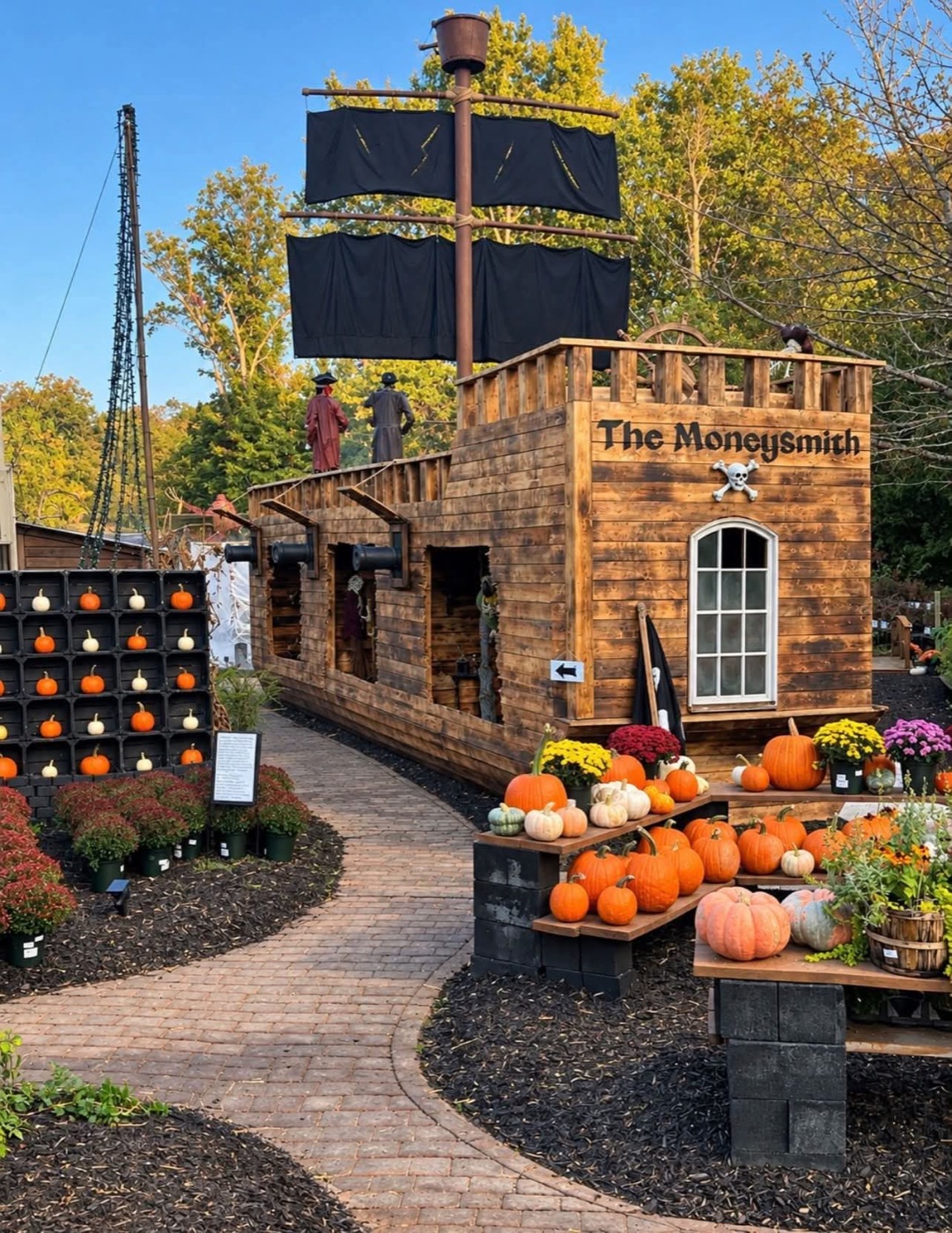 The pirate ship on the haunted trail, with pumpkins and mums along the path